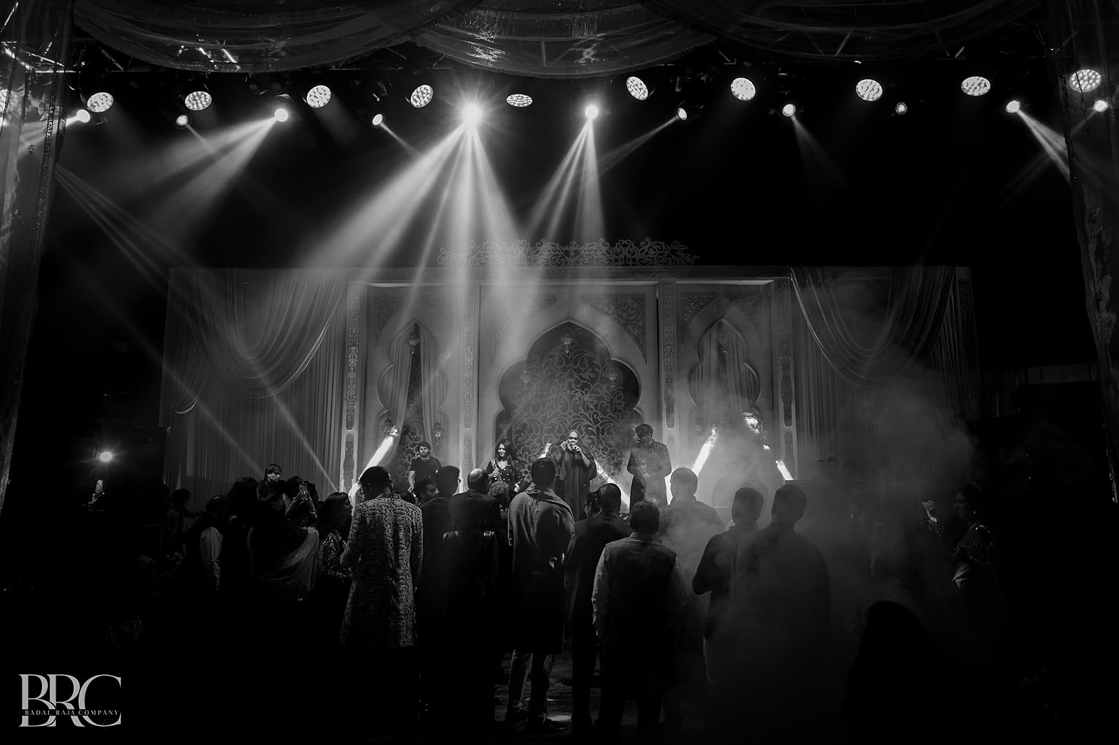 Guests enjoying a live wedding performance beneath stage lights